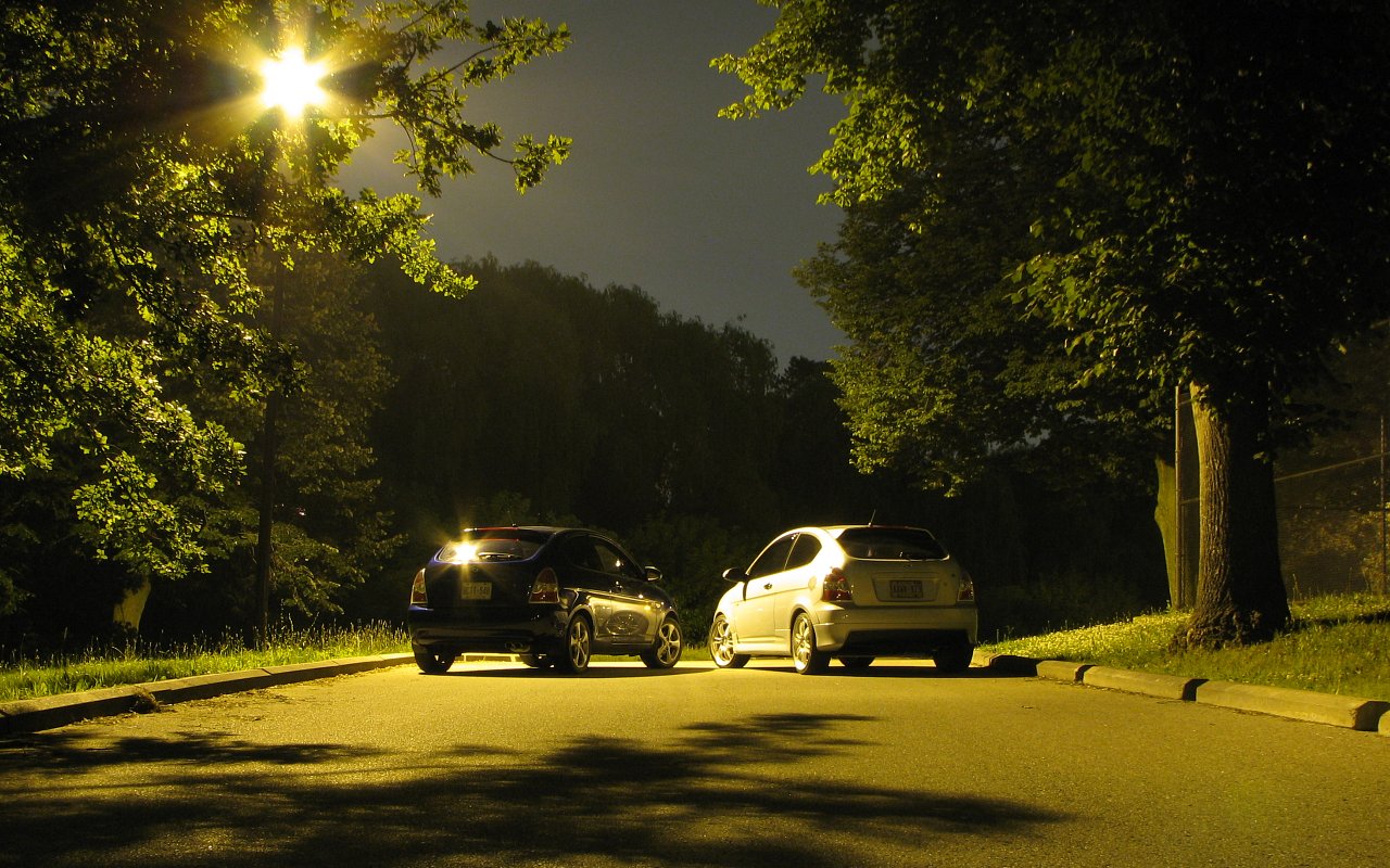 a street at night with police cars parked in the middle