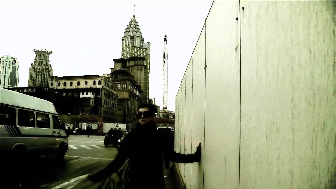 a man standing on a street corner holding a large wall