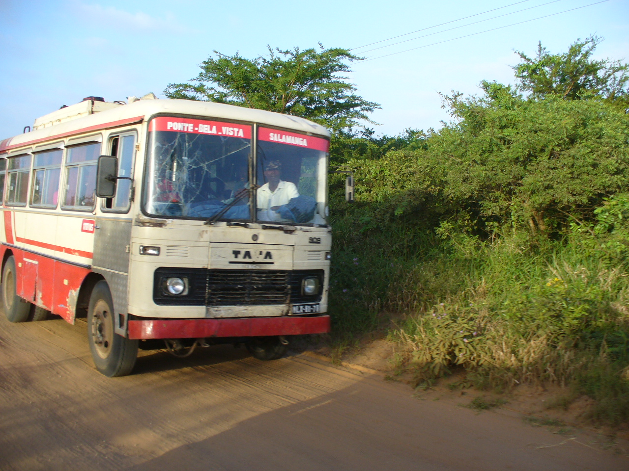 a red and white bus driving down the road