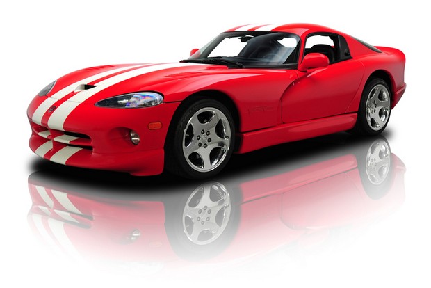 a red sports car with white stripes sitting in a studio setting
