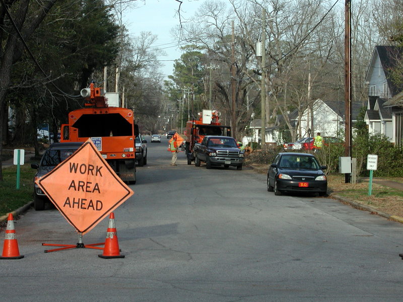 an orange work area ahead sign next to orange traffic cones