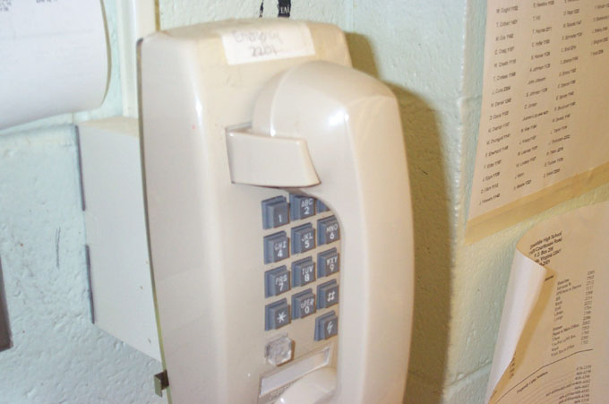 a phone mounted to a wall on a wall with papers