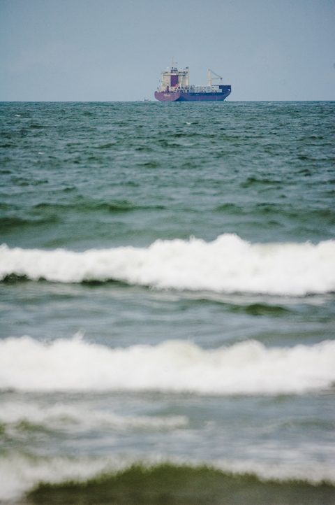 an ocean boat floating near another ship in the distance