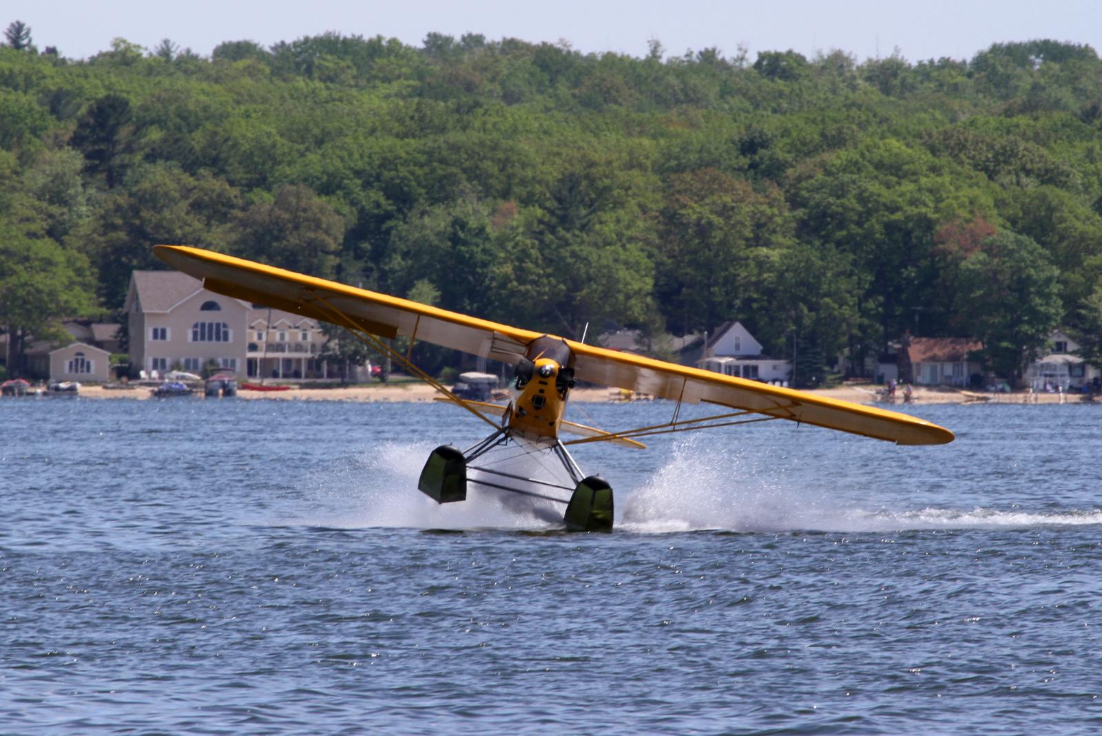 a biplane flying in the sky over the water
