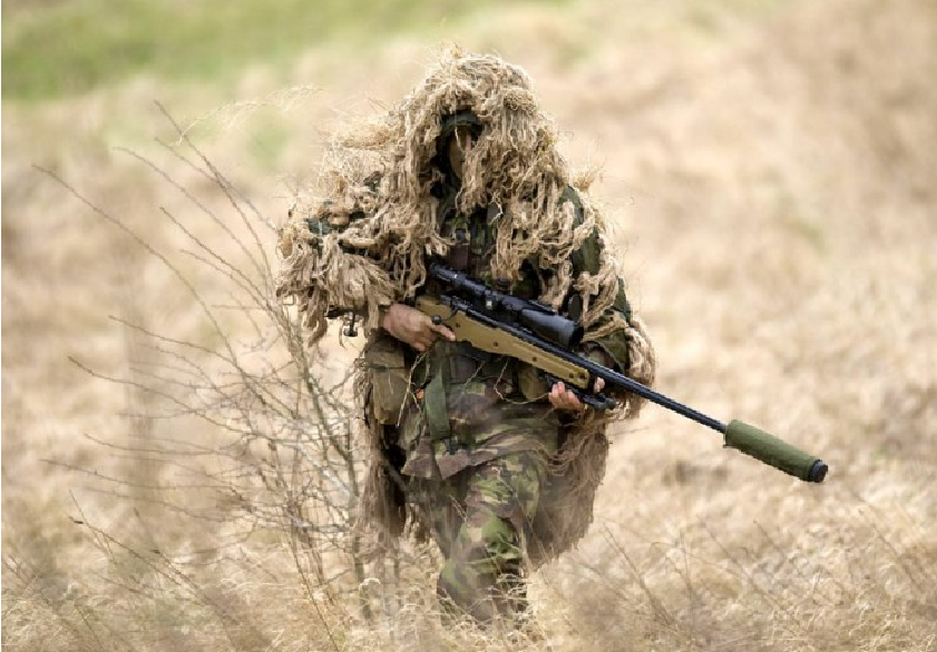 the armed soldier walks down a path with a rifle