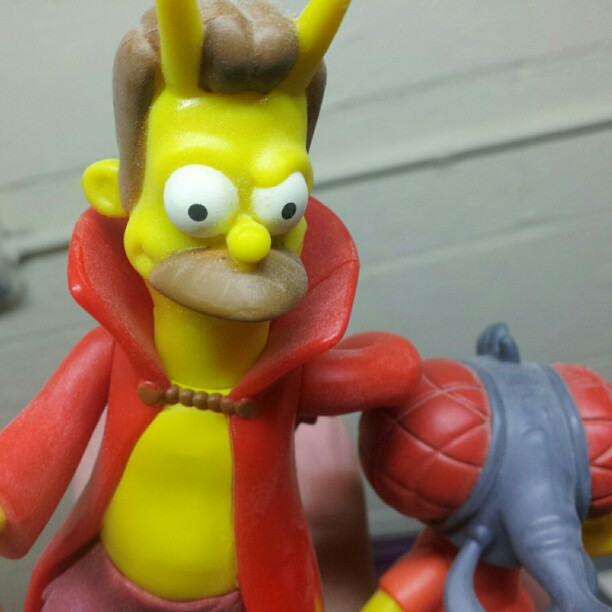 the simpsons character is sitting next to a toy horse