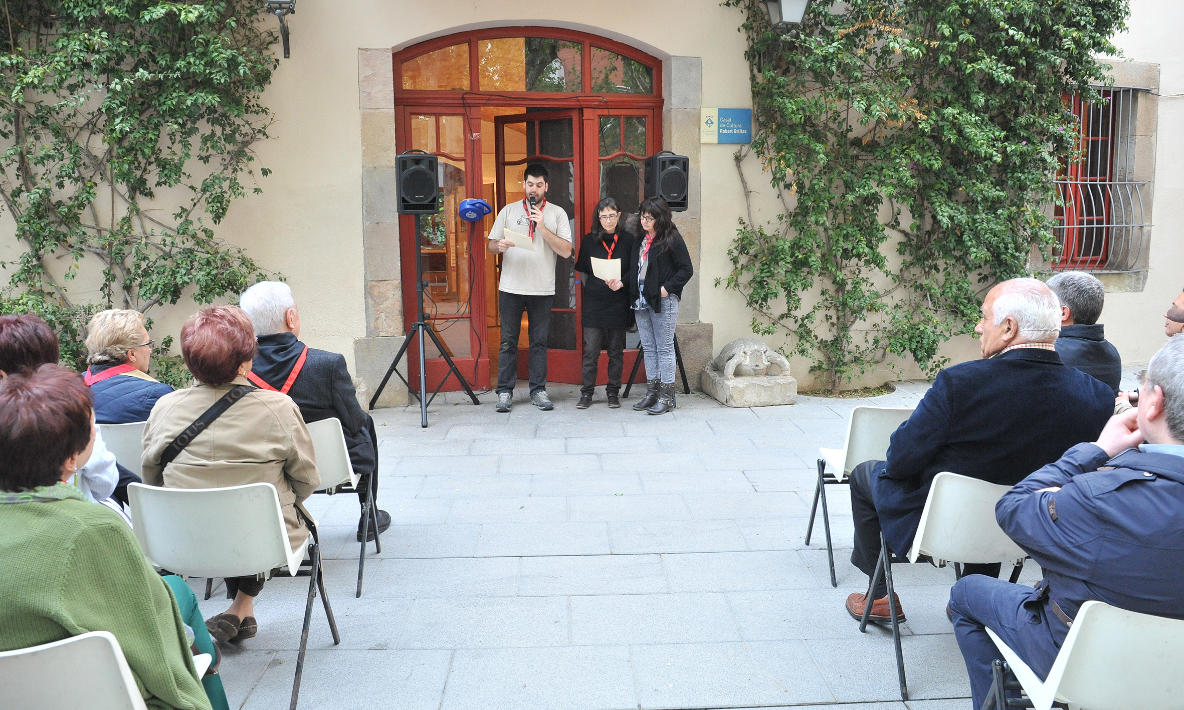 some people are sitting and standing in front of an entrance