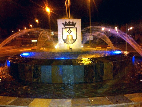 a fountain with colorful lights in the background