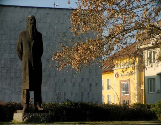 a statue in front of a large white building