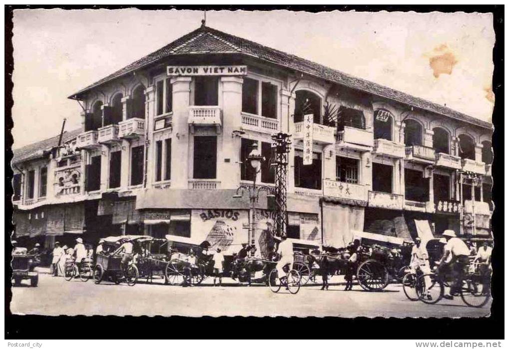 a vintage po shows people and horse drawn carriages in front of a building