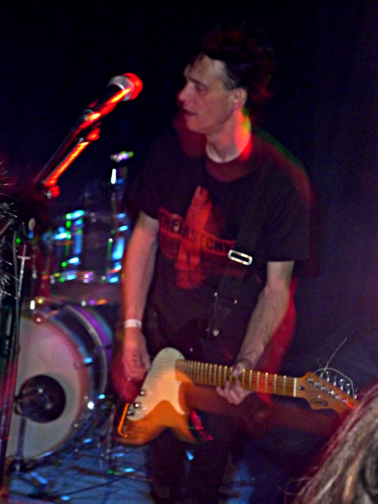 a man is playing the guitar in a dark room