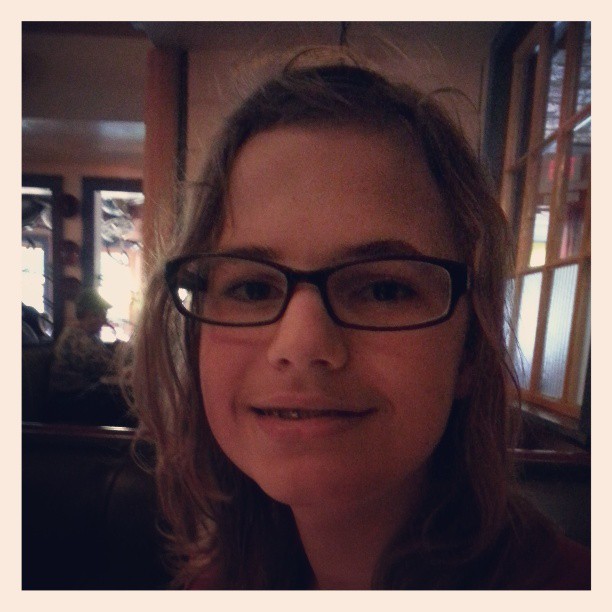 a lady wearing glasses and smiling for the camera