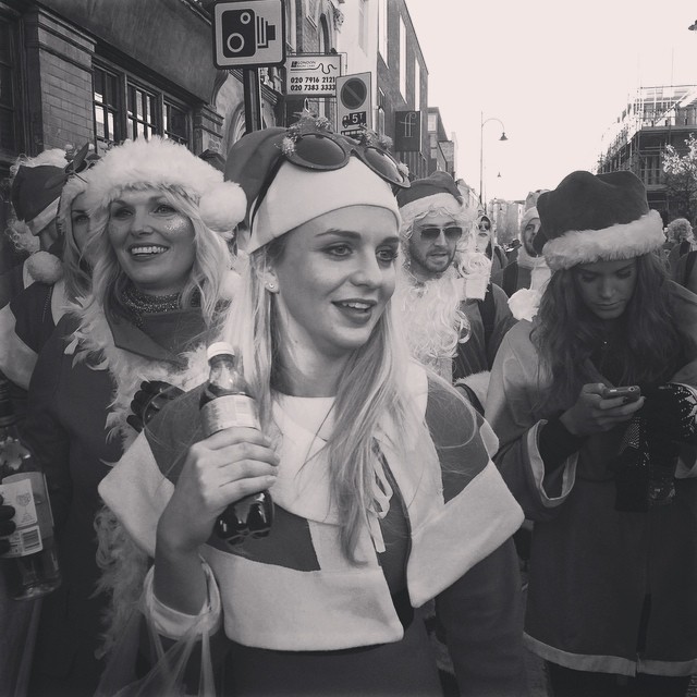 women dressed in santa hats and costumes with cell phones