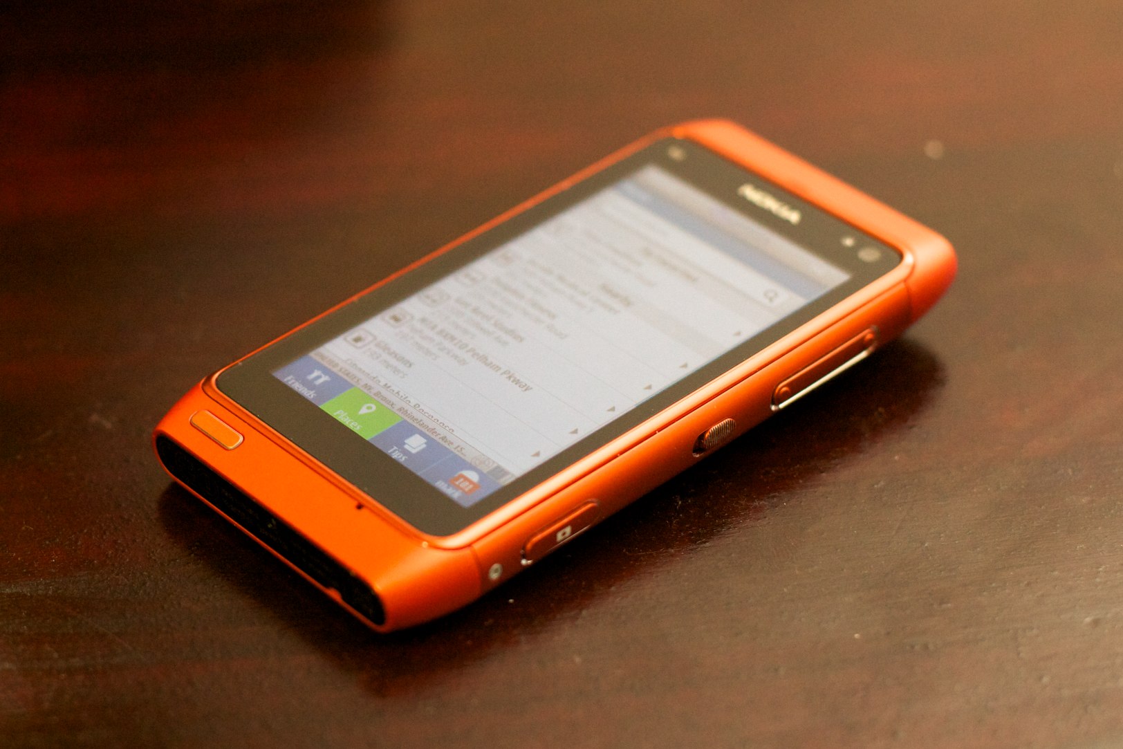 an orange cell phone on a wooden table