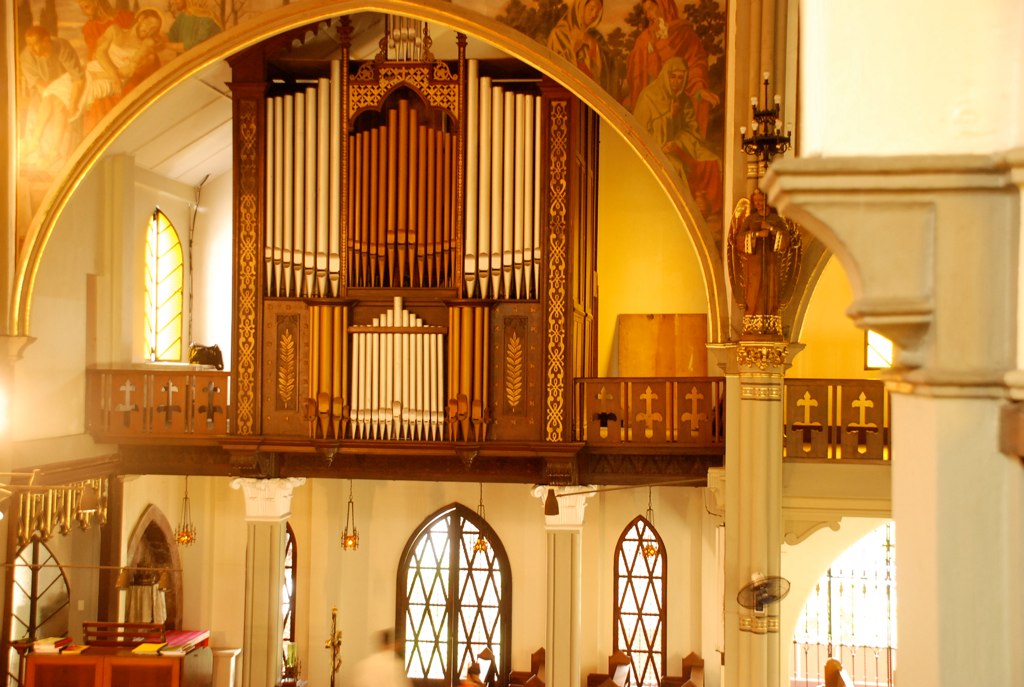 the choir of a church with a high, golden organ