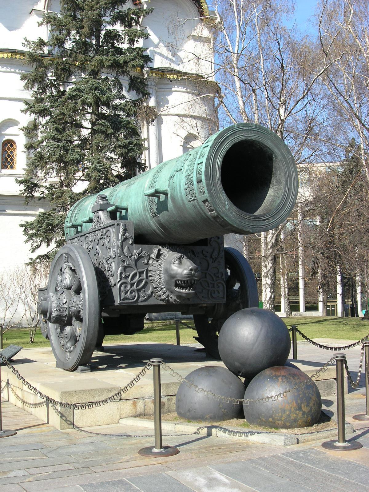 two large balls and a large cannon on display in front of the palace