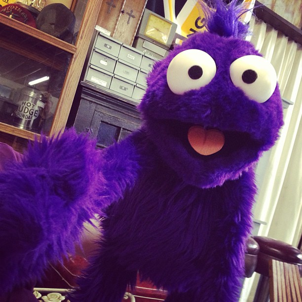 a purple stuffed animal with big googly eyes