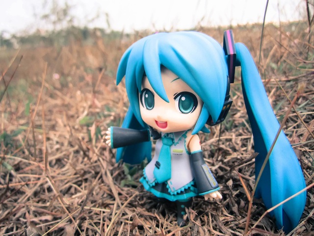 an anime doll with long hair is in the middle of a field