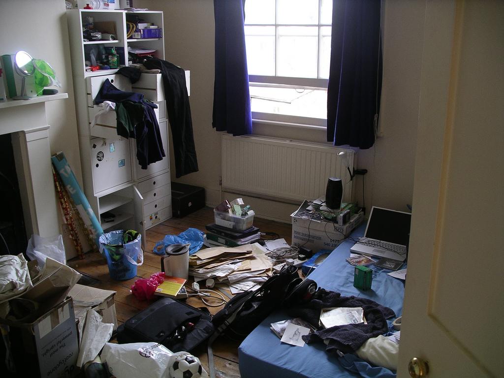 the room is cluttered with clothes and clutter