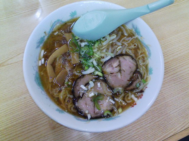 a white bowl filled with meat, noodles and noodles