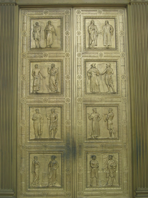 several decorative paintings are in the side of an antique metal door