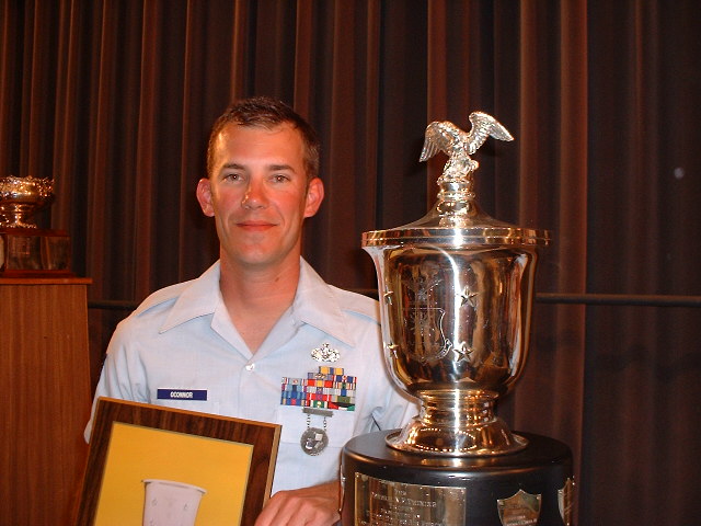 the man in uniform is showing off his trophy