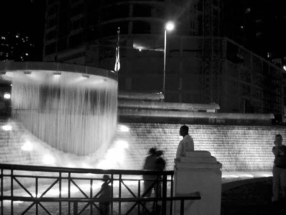 people sitting in front of water fountain at night