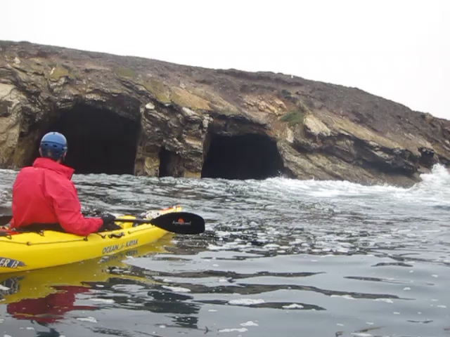a person riding in the back of a yellow kayak