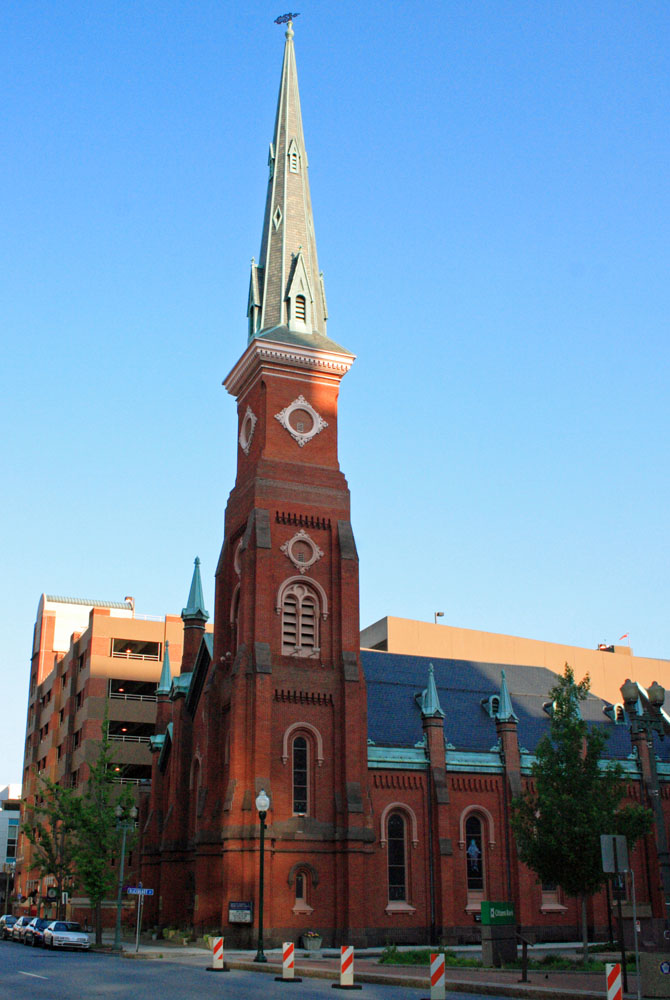 the large cathedral is red brick with black roof