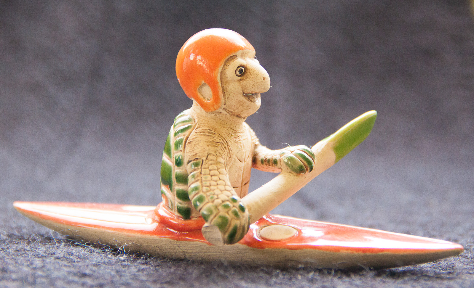 a plastic animal sitting on top of a surf board