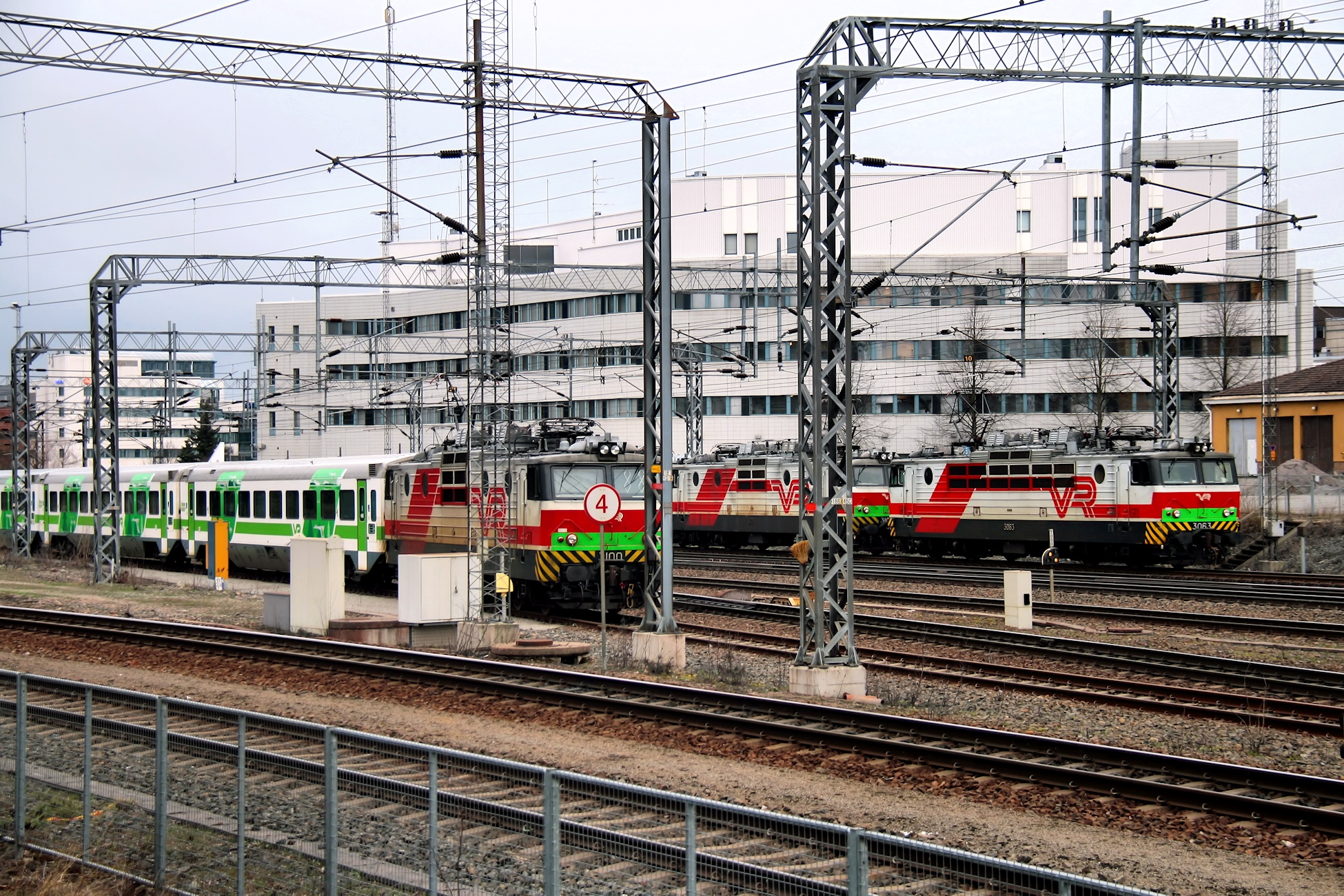 a green and red train passing through the city
