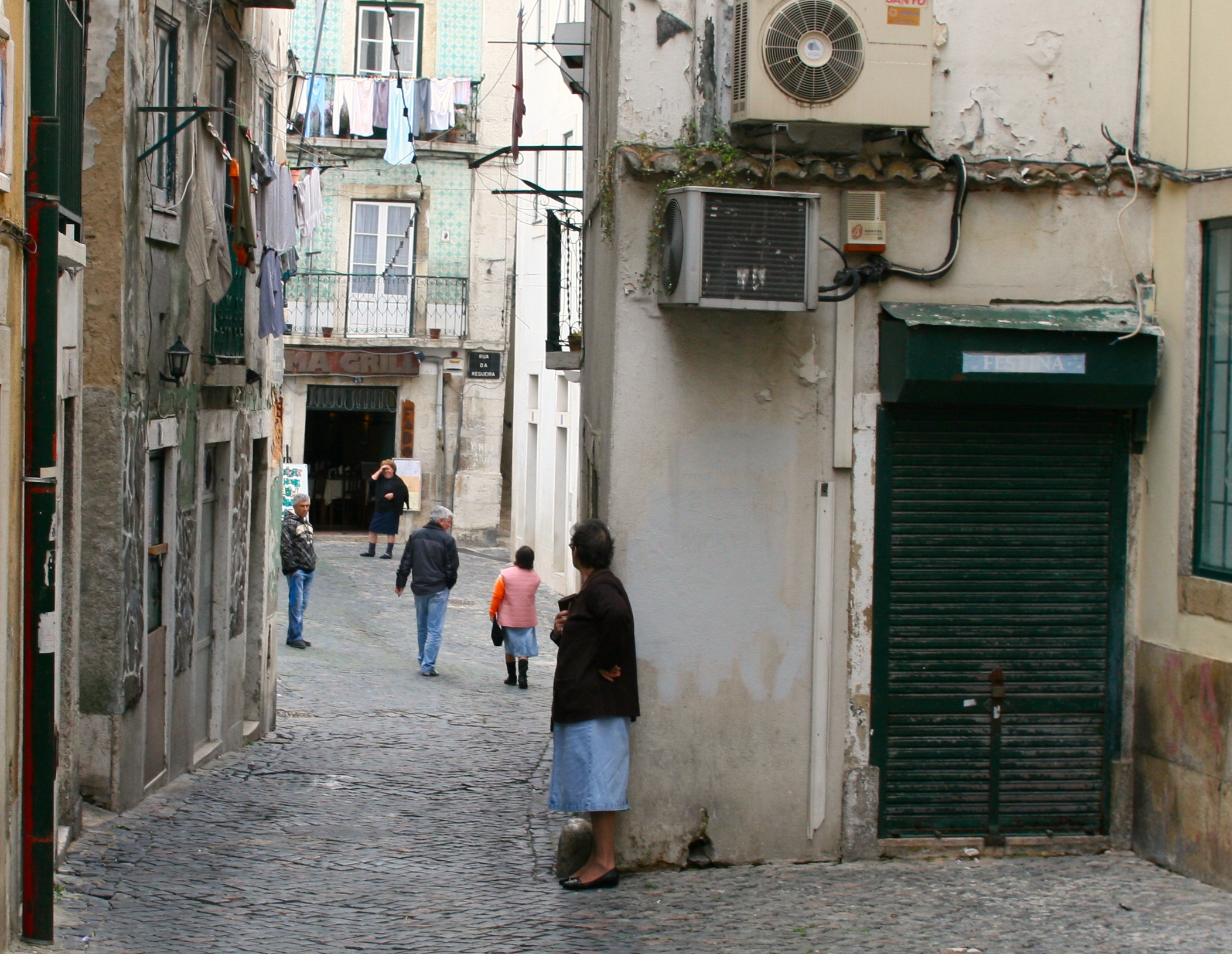 a woman is standing against the wall in the alley way