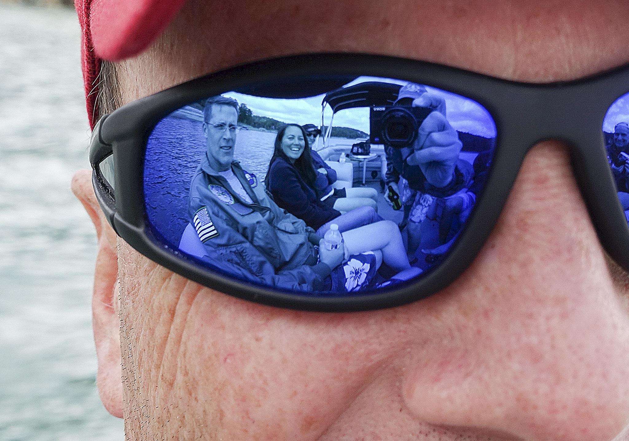 a man with two people reflected in his sunglasses