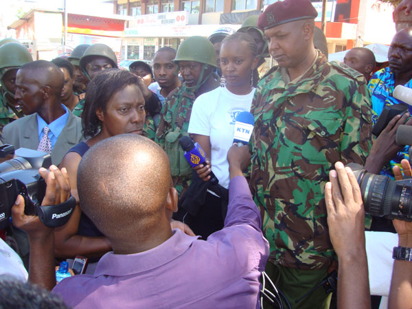 people in military uniforms and one person is holding a microphone