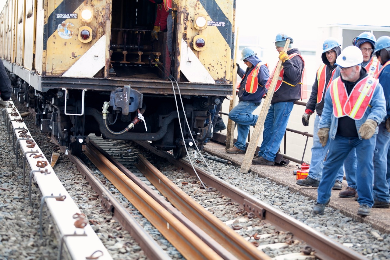 workers working on a rail with their train engine