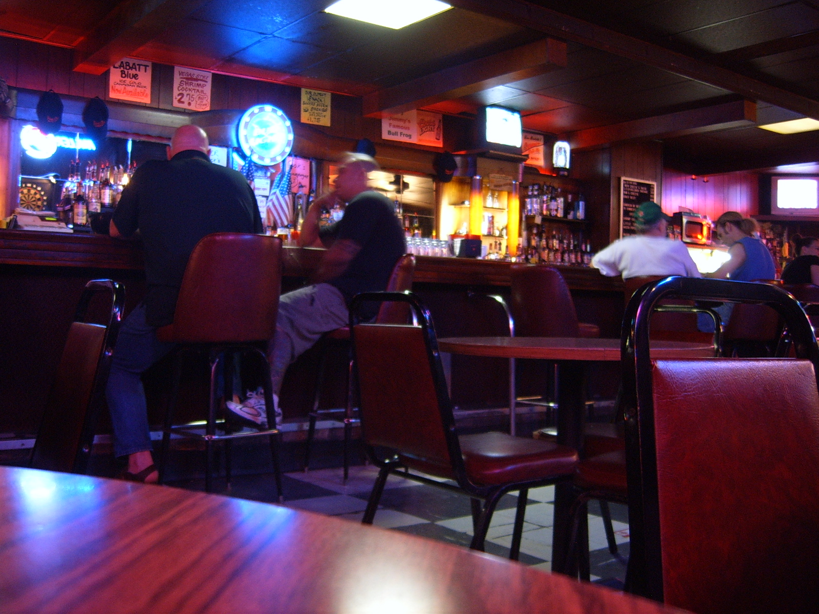 a man standing behind a bar next to a crowd of people