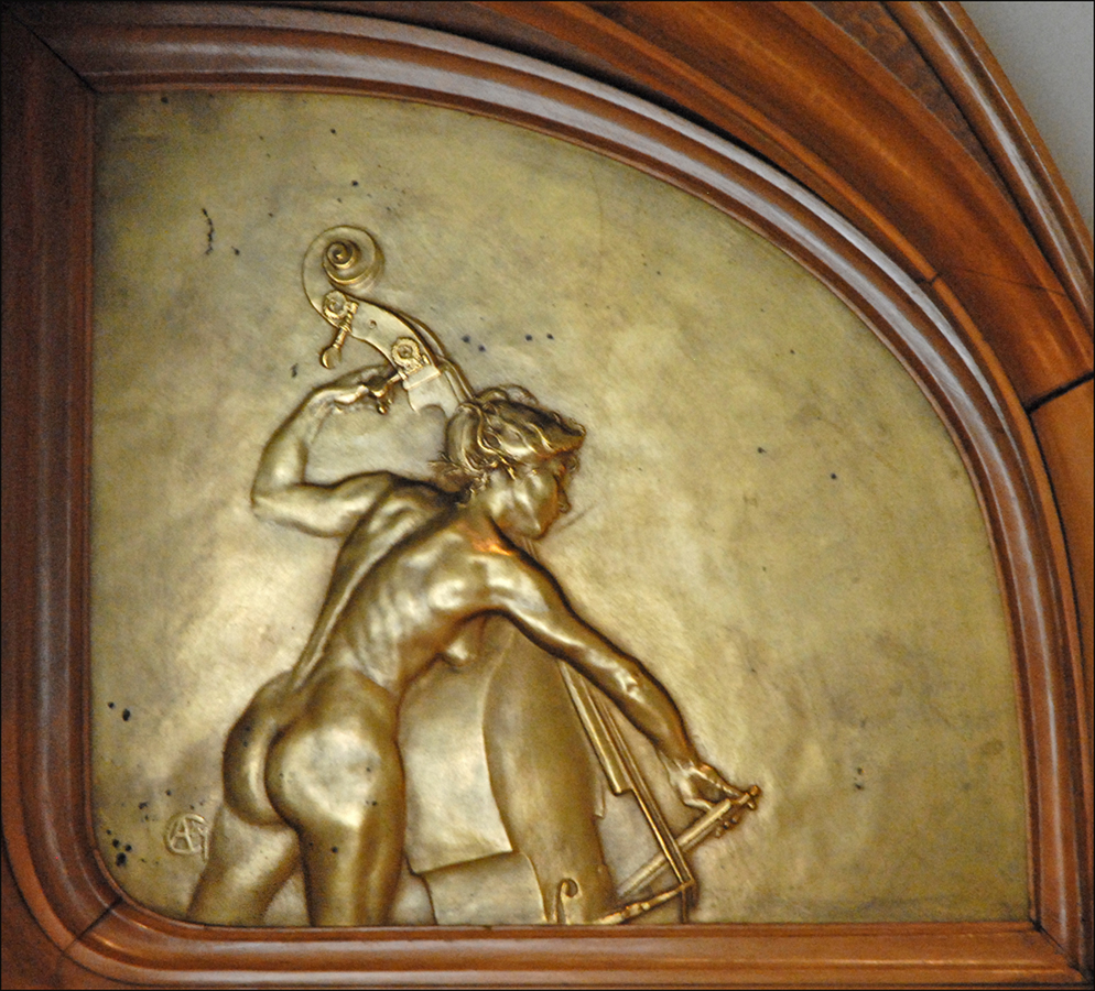 the bronze painting shows a person kneeling on a stool with an umbrella