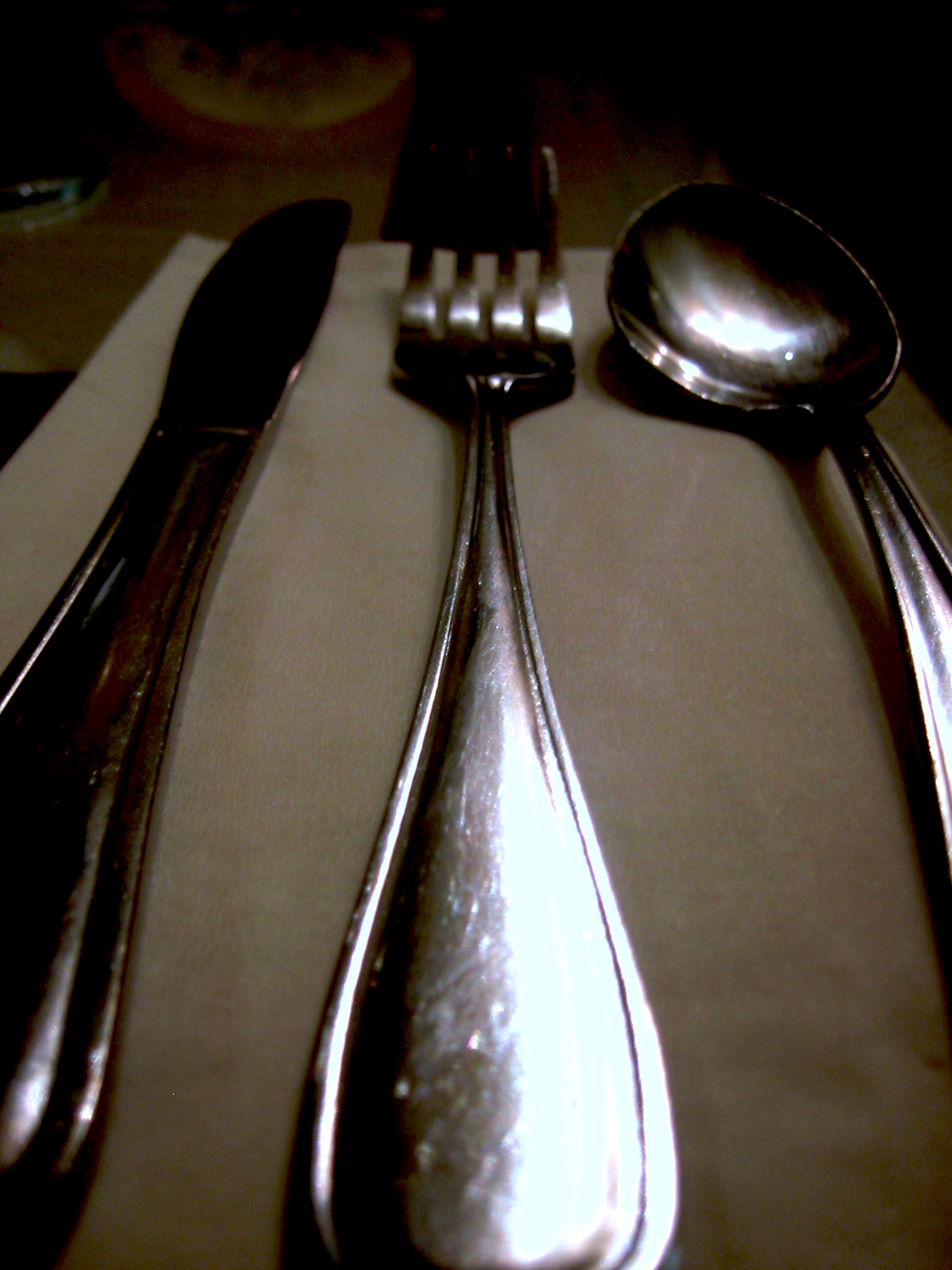 silverware sits on top of a table with a beige cloth