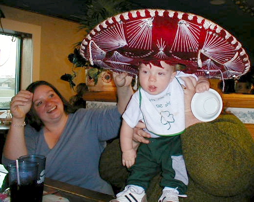 a mother holding her small child wearing a large sombrero