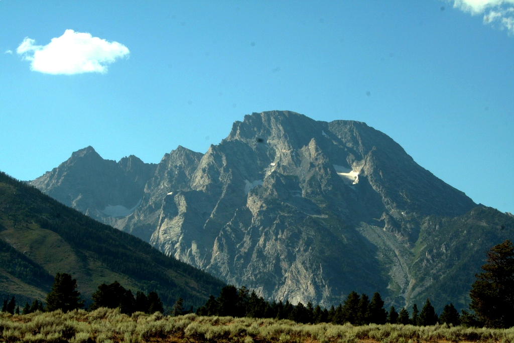 the high mountains rise high above the field