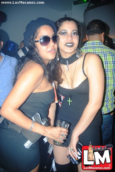 two women pose for a po at a night club