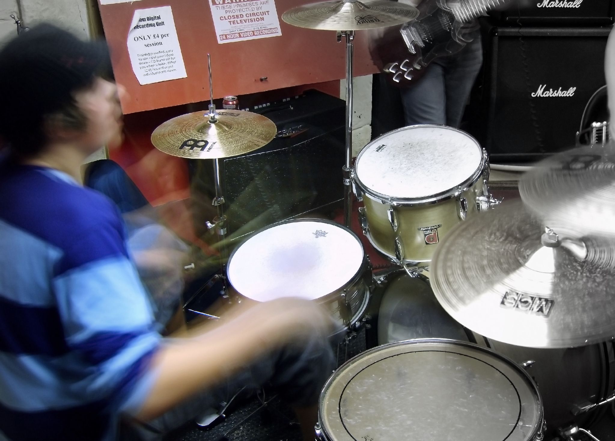 two boys playing drums with other music equipment