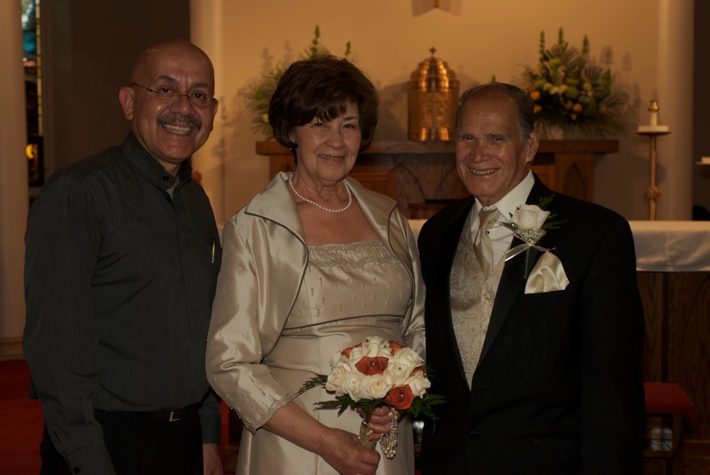 two men and a woman standing together in a church