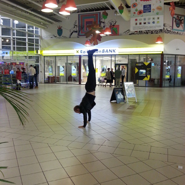 a person in the air above his head on a tiled floor