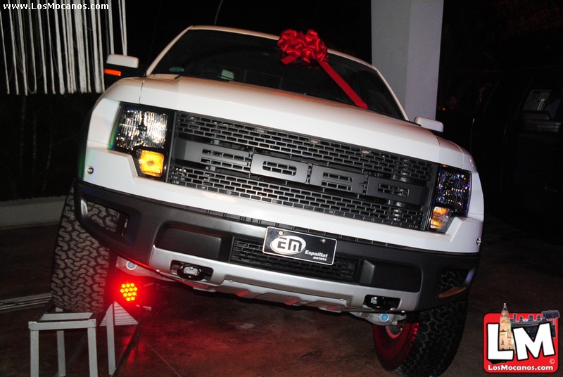 the truck has red bow tied to its hood