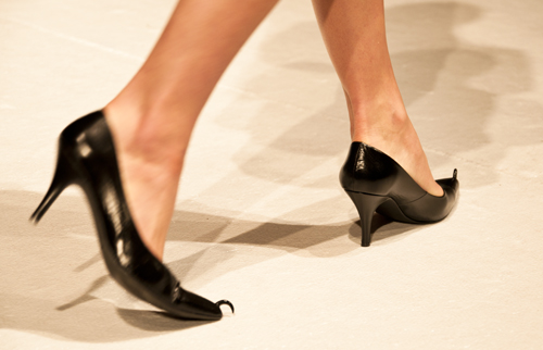 a woman's foot is shown wearing a pair of high heels
