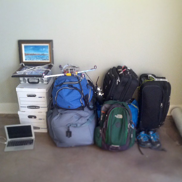 luggage and suitcases piled on the ground in front of a framed picture
