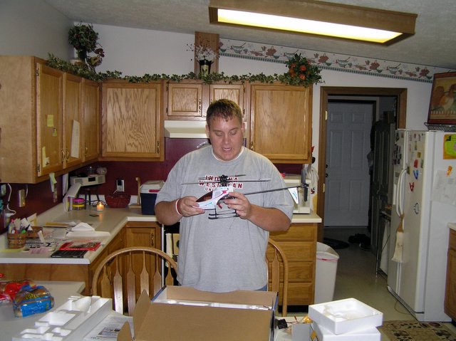 a man standing in a kitchen holding some paper