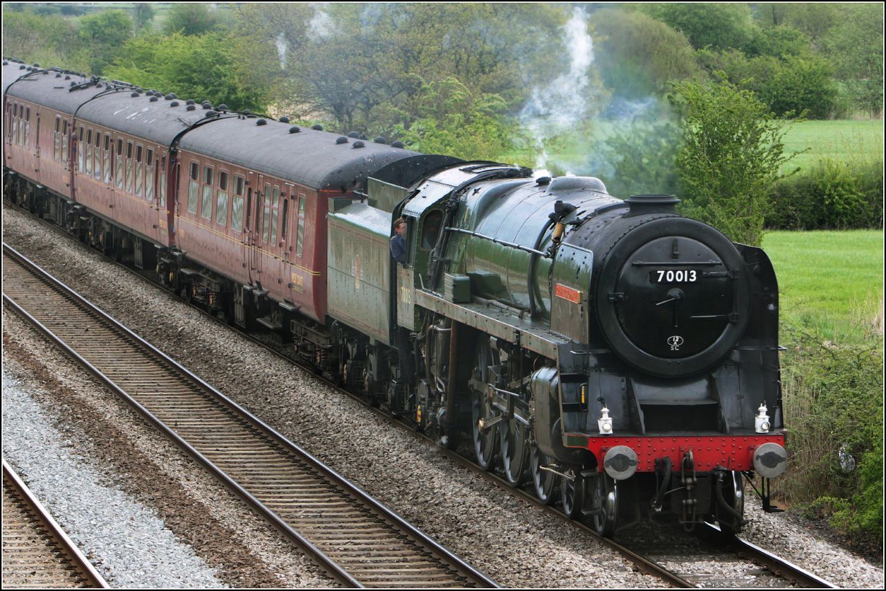 a steam engine train on some tracks and smoke coming from the top