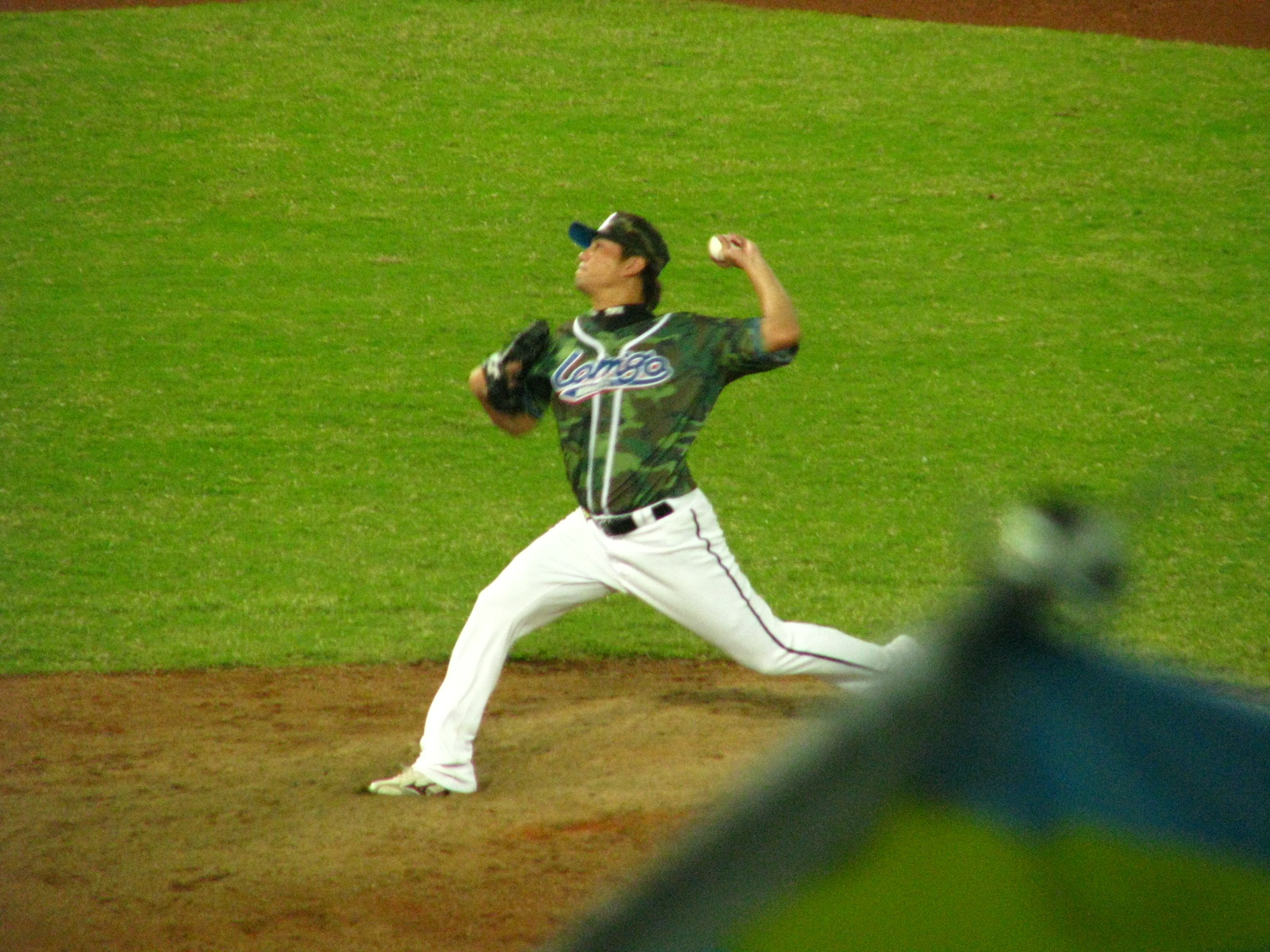 the baseball player is pitching on a grassy field